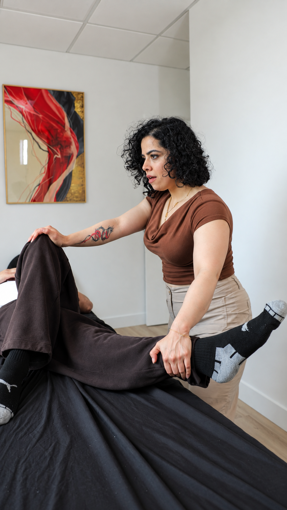 Osteopath performing TENS therapy on patient shoulders at Flux Thérapeutique Montreal